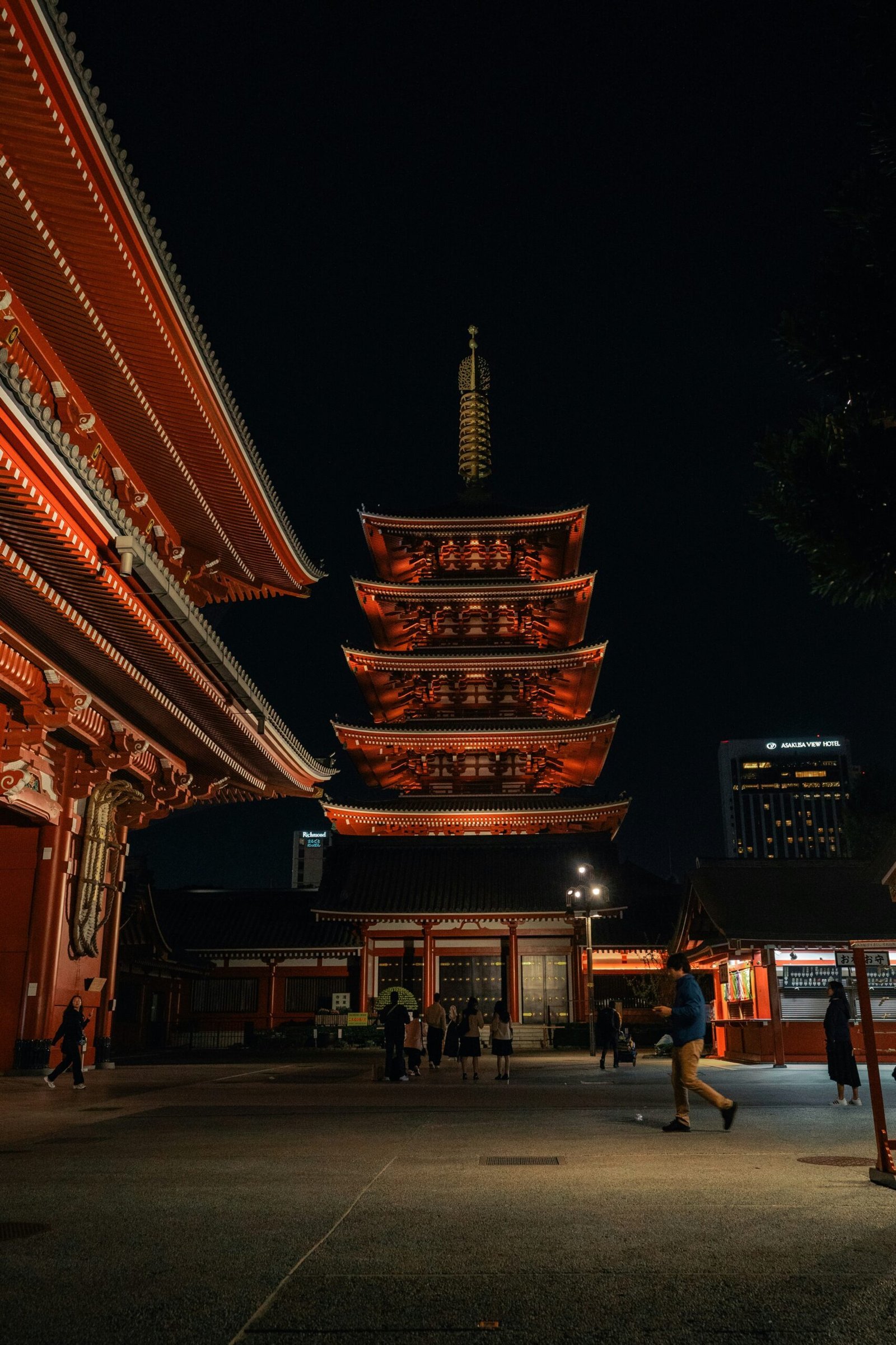 a person walking in front of a building at night